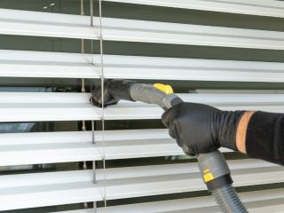 Eco-friendly cleaning solution being applied to fabric window shades.