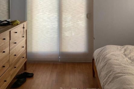 Elegant custom roller sheer shades fully lowered on a Concord bedroom’s patio door, creating a soft and private ambiance.